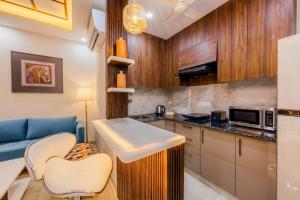 a kitchen with a sink and a blue couch at Kyomi Service Apartments in Gurgaon