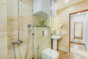 a bathroom with a shower and a toilet and a sink at Kyomi Service Apartments in Gurgaon