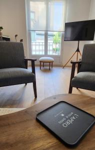 a living room with two chairs and a mat on a table at Les Hortensias Roses Duplex in Amiens