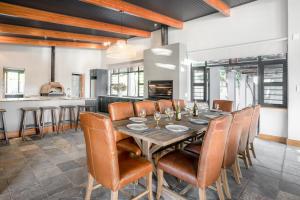 una sala da pranzo con tavolo e sedie in legno di Avemore Manor House wood fired hot tub magical views and full Backup power a Stellenbosch