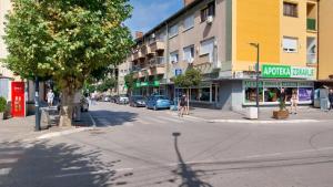 a city street with people walking down the street at Apartman EmEm in Kuršumlija