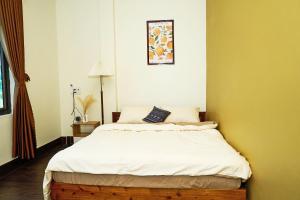 une chambre avec un lit avec des draps blancs dans l'établissement Sen's Homestay - Motorbike Rental - Tours- Cao Bang City, à Cao Bằng 51 autres photos