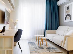 a living room with a white couch and a table at Parkside Haven in M. Ciurel