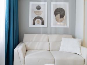 a white couch in a living room with two pictures at Parkside Haven in M. Ciurel