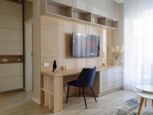 a room with a desk with a tv and a chair at Parkside Haven in M. Ciurel