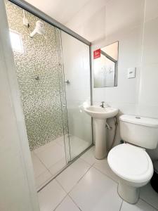 a bathroom with a shower and a toilet and a sink at Hotel Oiticica in Fortaleza