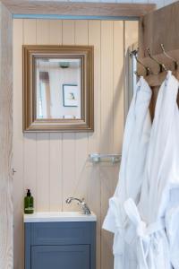 クレディトンにあるRomantic Shepherds Hut, Devon with outside bathのバスルーム(シンク、鏡、白いタオル付)