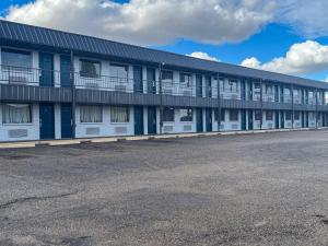 un immeuble d'appartements avec des fenêtres blanches et bleues et un parking dans l'établissement Motel 6 Borger, TX Boom Town, à Borger
