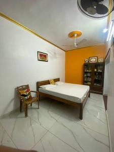 a bedroom with a bed and a chair in it at Abhiraj stay in Ayodhya