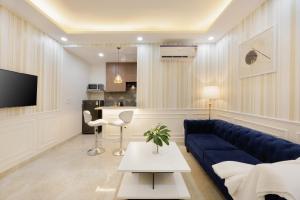 a living room with a blue couch and a table at Kyomi Service Apartments in Gurgaon