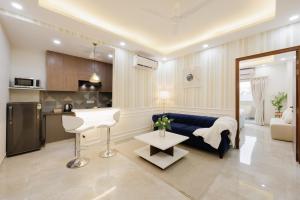 a living room with a blue couch and a table at Kyomi Service Apartments in Gurgaon