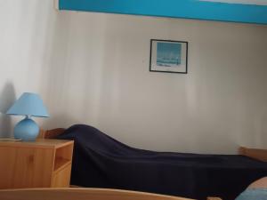 Appartement vue port - Port Leucate في بورت لوكات: غرفة نوم بها سرير وطاولة ومصباح