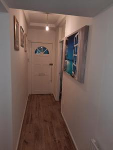 a hallway with a white door and a wooden floor at Homely Space in Havering, Essex in Havering atte Bower +1 photo