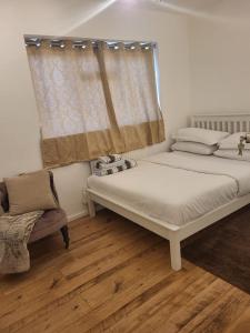 a bedroom with a bed and a window at Homely Space in Havering, Essex in Havering atte Bower