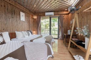 two beds in a room with wooden walls at Bamboo Hill Villa in Ninh Binh