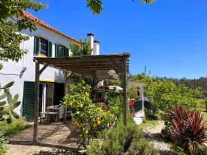 a garden in front of a house with a pergola at Quinta Vida Verde in Alvaiázere