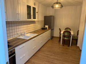 a kitchen with a sink and a table and a refrigerator at Vintage Villa in Shkodër