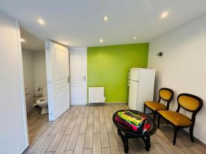 a room with two chairs and a green wall at Studio T2 proche Jardin de Plantes Rouen in Rouen