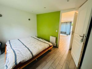 a bedroom with a bed and a green wall at Studio T2 proche Jardin de Plantes Rouen in Rouen