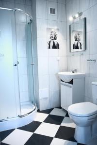 a bathroom with a shower toilet and a sink at Leo Hostel in Poznań