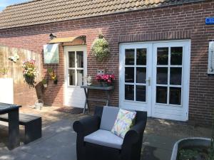 a patio with a chair and a door at Villa Pats in Gilze