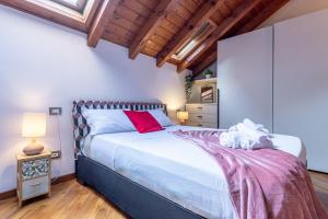 ミラノにあるRomantic Suite Navigli - 15min Duomo - FREE parkingの大きなベッドと木製の天井のある寝室