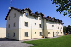 a large white building with a roof at Leo Hostel in Poznań