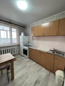 a kitchen with wooden cabinets and a white refrigerator at Трёхкомнатная квартира в центре Борового in Borovoye