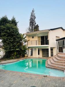 a swimming pool in front of a house at Mondeor Homestay in Johannesburg
