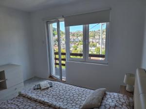 une chambre avec un lit et une grande fenêtre dans l'établissement Apartman Look, à Jajce