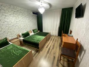 a room with two beds and a table and chairs at Villa de Nord in Soroca