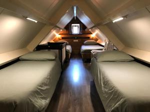 a attic room with three beds and a window at Villa Pats in Gilze
