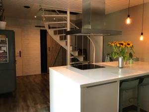 a kitchen with a white counter top and a staircase at Villa Pats in Gilze
