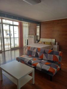 ein Wohnzimmer mit einem Bett und einer Couch in der Unterkunft Apartamento Playa Gandía in Playa de Gandia