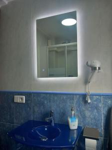 ein Badezimmer mit einem blauen Waschbecken und einem Spiegel in der Unterkunft Apartamento Playa Gandía in Playa de Gandia + 16 Fotos