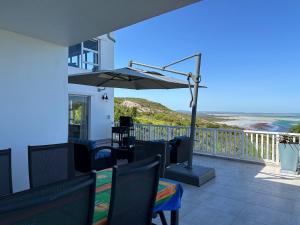 a patio with a table and an umbrella at Lagoon Views at Langebaan in Langebaan