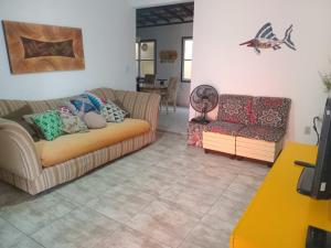 a living room with two couches and a table at Casa em Cabo Frio in Cabo Frio