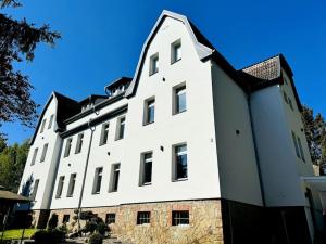 a large white building with a black roof at 1923 Wohnung by Gerda in Etgersleben