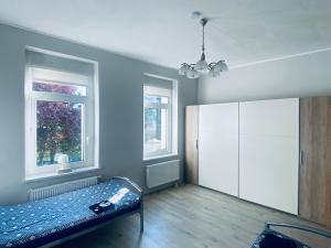 a bedroom with a bed and two windows at 1923 Wohnung by Gerda in Etgersleben