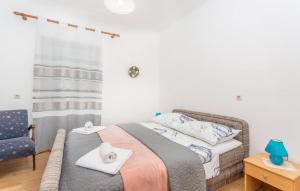a bedroom with a bed with towels and a chair at Apartman ALEN in Klanice Dobrinj