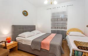 a bedroom with two beds and a clock on the wall at Apartman ALEN in Klanice Dobrinj