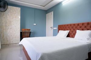 a bedroom with a large bed with blue walls at Haya Residency in Alleppey
