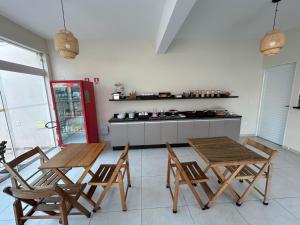a kitchen with two wooden tables and chairs at Hotel Jardim Emilia Sorocaba in Sorocaba