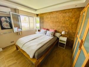 Un dormitorio con una cama y una pared de ladrillo. en Puerto Rico duplex with community pool close to the beach, en Puerto Rico de Gran Canaria