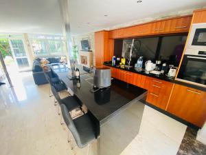 una cocina con encimera negra y algunas sillas en Puerto Rico duplex with community pool close to the beach, en Puerto Rico de Gran Canaria