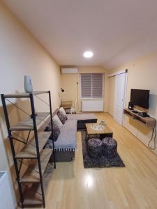 een woonkamer met een bank en een tafel bij NIKA apartman stan na dan in Šabac +3 foto's