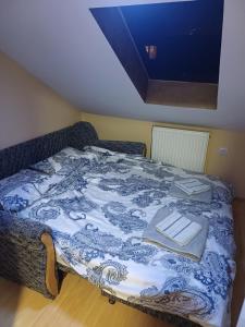 een bed met een blauwe en witte deken erop bij NIKA apartman stan na dan in Šabac