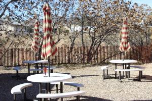 a group of tables with umbrellas in a park at Fort Verde Suites in Camp Verde