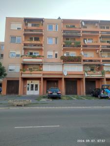 a large apartment building with cars parked in front of it at LBB apartman in Sátoraljaújhely +18 photos