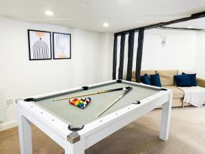 a pool table in a living room with a couch at Chelmsford City - 17th Century Apartment in Chelmsford